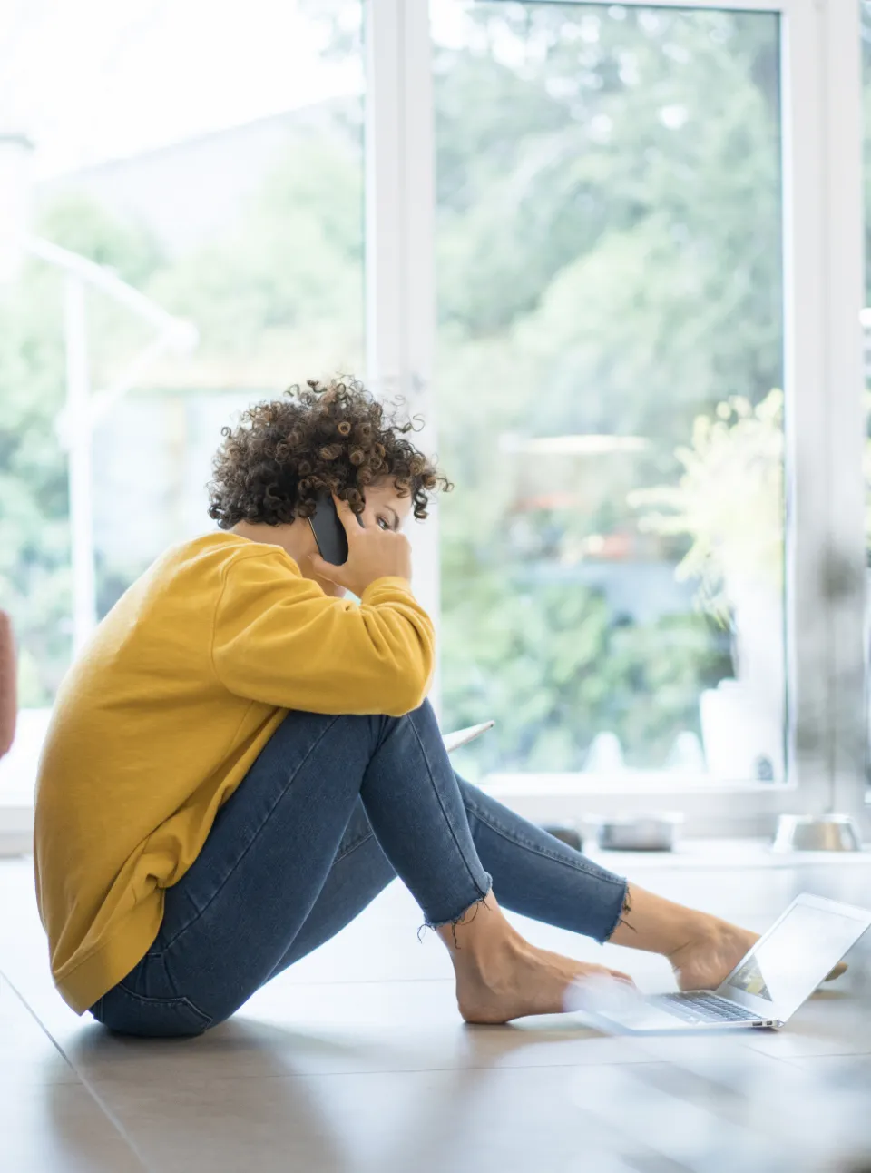 A patient sitting on the ground talking on the phone.